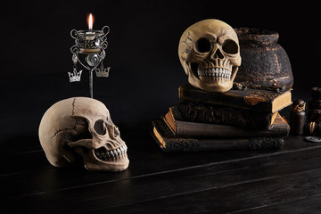 Realistic model of a human skull with teeth on a wooden dark table, black background. Medical...
