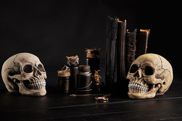 Realistic model of a human skull with teeth on a wooden dark table, black background. Medical...
