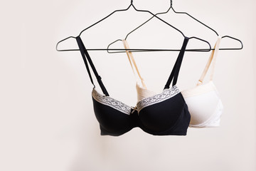 Stylish lingerie. Variety of bra hanging on a hanger. Set of female underwear. Advertise or sale concept