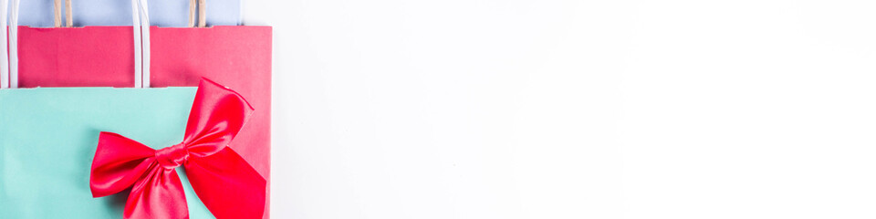 Christmas shopping and sale concept. Buying Christmas gifts. Pastel colored paper bags with xmas  and New Year gifts. On white background copy space