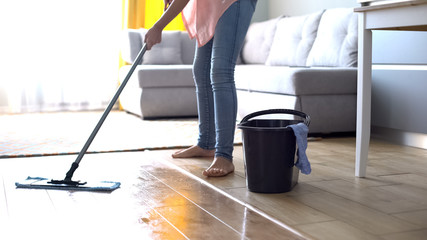 Woman mopping floor, tips for correct cleaning wooden surface, linoleum or tile