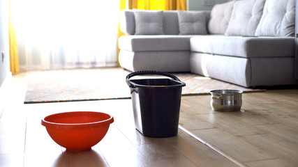 Water dropping in bucket and dishes from ceiling, risk of shingles, damaged roof