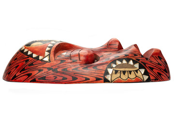 Side view of the wooden red mask from Thailand, decorated with black and white patterns, isolated on white background