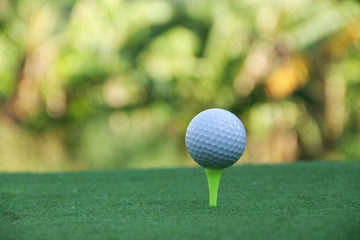 Golf ball on tee in beautiful golf course
