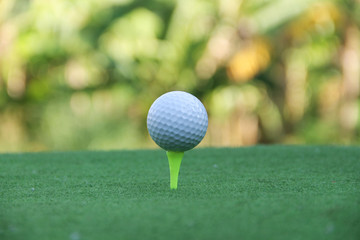 Golf ball on tee in beautiful golf course