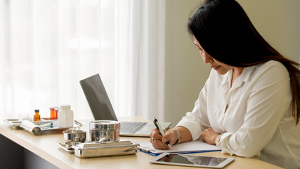  Portrait Asian  Woman  doctor sitting at desk working at medical office