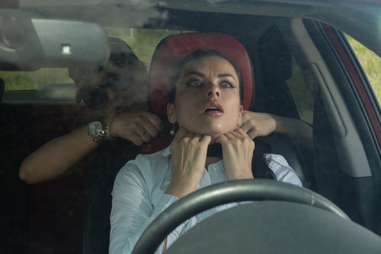 Scene from a detective series. Killer strangles business woman in her car...