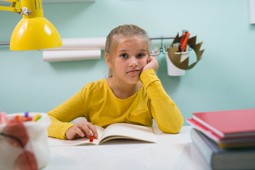 cute little girl sitting desk in her room doing homework