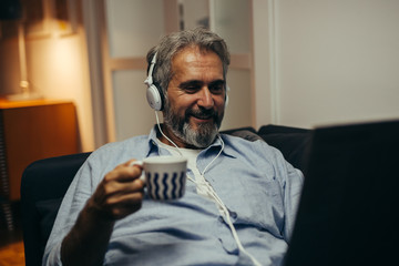 man listening music on headphones in his home