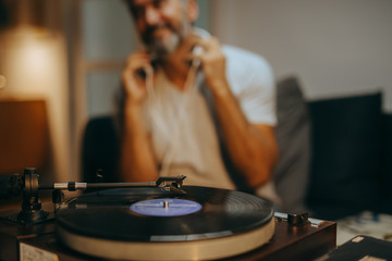 man listening music on record player in his room