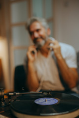 man listening music on record player in his room