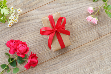 Gift box with flowers on the wooden background.