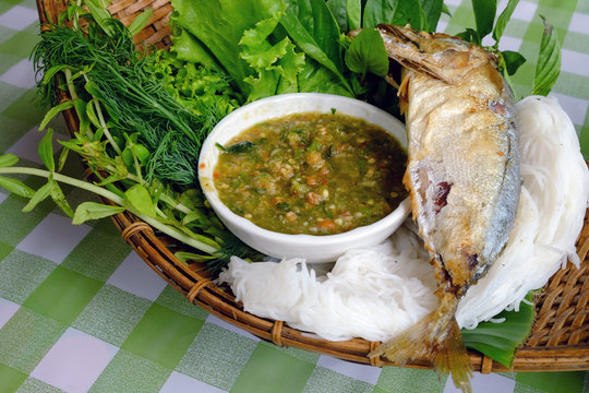 Fried mackerel fish served with fresh vegetable, special sauce and fermented rice flour noodles