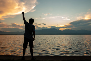 Fototapeta premium silhouette of man over sky and sun light background,business, success, leadership, achievement and people concept