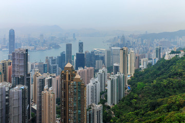 Fototapeta na wymiar View on Skyscrapers with Victoria Bay, Transportation Ships, Harbour and Kowloon taken from Hongkong Island Peak. Hong Kong, China