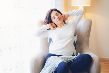 Happy relaxing woman stretching in front of at home.