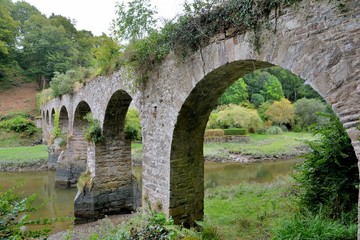 Fototapeta na wymiar Vieux pont de pierres en granit sur le Guindy. Bretagne, France