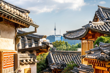 Obraz premium Wioska Bukchon Hanok w Seulu z widokiem na dachy tradycyjnych domów i wieżę w oddali w Korei Południowej