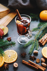 Christmas mulled wine or gluhwein with apple and orange slices in glass. Traditional drink on...