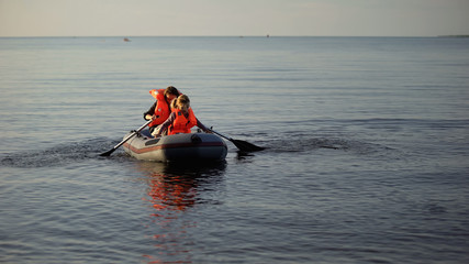 Woman and girl in life jackets rowing boat, touristic trip, entertainment