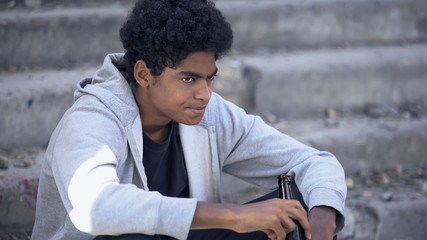 Desperate thoughtful black male thinking of problem, holding beer bottle