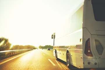 scene of trip on tourist bus by highway in warm tones in selective focus on drver mirror