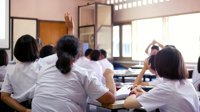 High school students are actively studying science by raising their hands to answer questions that teachers ask them, Thailand, southeast Asia.