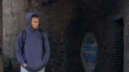 Sad black teenager walking alone abandoned building, puberty loneliness, problem