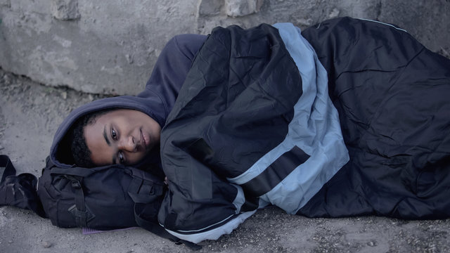 Desperate Black Man Lying Street Covered With Sleeping Bag, Poverty Hopelessness