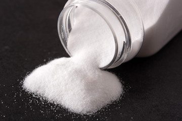 Baking soda in a poured bottle on black background