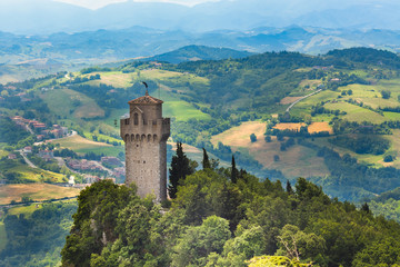 Fototapeta na wymiar Tower Montale or Terza Torre Montale or Third fortress tower on Monte Titano, Republic San Marino. Aerial top view of landscape valley and hills of suburban district