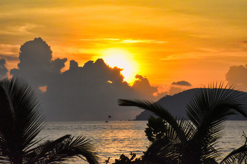 Amazing, wonderful and dramatic golden colored sky behind the clouds during a stunning sunset