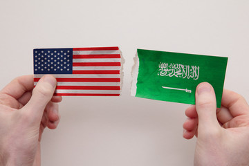 USA and Saudi Arabia paper flags ripped apart. political relationship concept