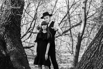 The masked maniac is preparing to attack the girl from behind. Black and white photo. Halloween.