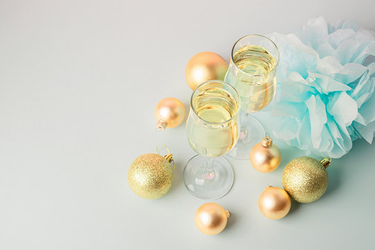 Champagne in glass goblets gold balloons stars serpentine a pastel delicate pink background. New year christmas concept.