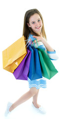 Teenager girl shopping in a store with large paper bags.