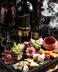 cheese plate with gouda, cheddar, goat and blue cheese, dried fruits and flowers