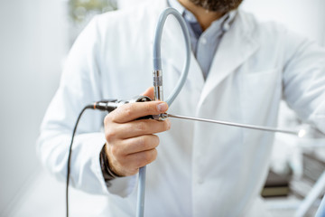 Otolaryngologist holding endoscope for examination of ENT organs, close-up view