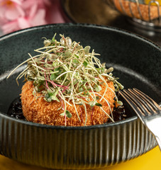crispy chicken nugget garnished with fresh herbs