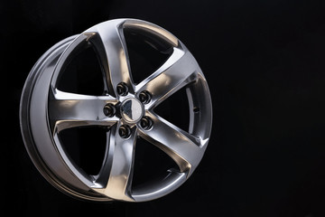 Aluminum metal wheel rim texture, beautiful chrome gray asphalt color Alloy car wheel on black background, blank space for text