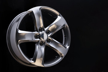 Obraz premium Aluminum metal wheel rim texture, beautiful chrome gray asphalt color Alloy car wheel on black background, blank space for text