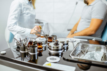 Otolaryngologist preparing for the medical examination procedure to a patient at the ENT office, close-up view on the medical tools