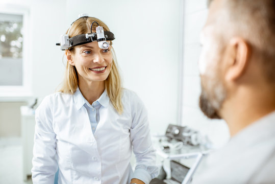 Portrait of a female confident otolaryngologist during a medical consultation with adult patient at the ENT office