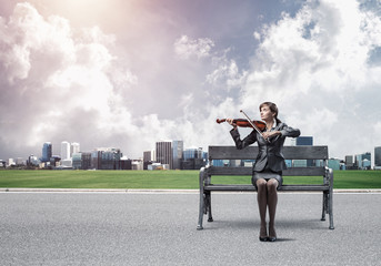Young woman with violin sitting on wooden bench