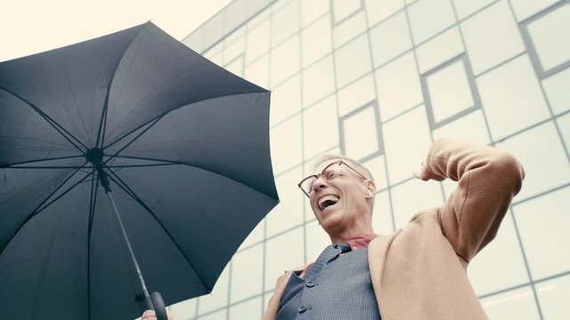 businessman holding umbrella, dancing, listening music 
