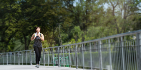 Portrait of an Asian woman wearing sport clothes, jogging and workout in the park in the morning. With good weather Exercise every day will make the body healthy and not sick. Concept Health insurance