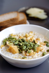 Oatmeal with fruit and pumpkin seeds for breakfast