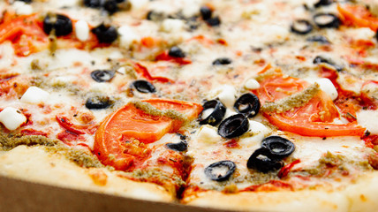 vegetarian pizza with olives, tomatoes and cheese.