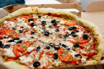 vegetarian pizza with olives, tomatoes and cheese.