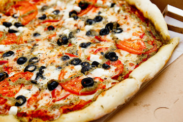 vegetarian pizza with olives, tomatoes and cheese.